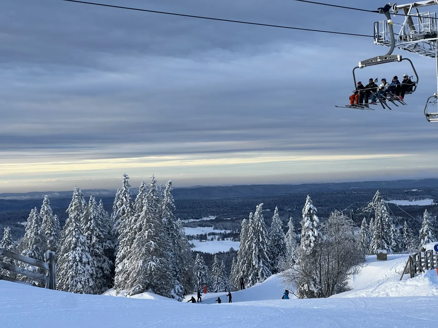 Looking west from the ski area — snow-covered Jura forest and the plateau below